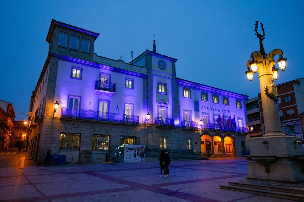 Fachada del Ayuntamiento de Colmenar Viejo iluminada de violeta por el 8M