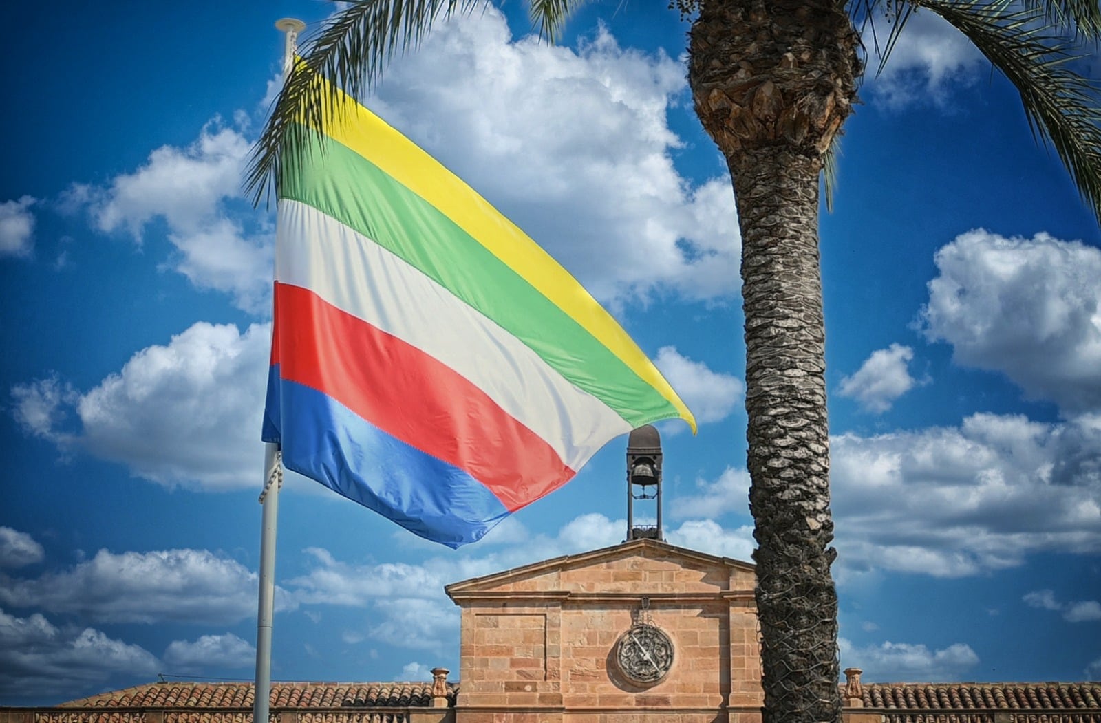 Bandera de Linares con el Ayuntamiento al fondo.