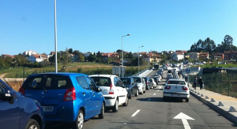 Colas a la entrada del Nuevo Hospital Álvaro Cunqueiro, con vehículos estacionados en la separación entre ambos carriles dificultando el tráfico