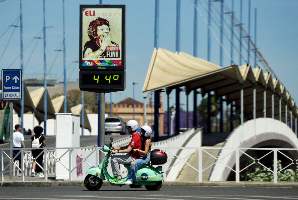 Una pareja pasea en una moto en Sevilla.