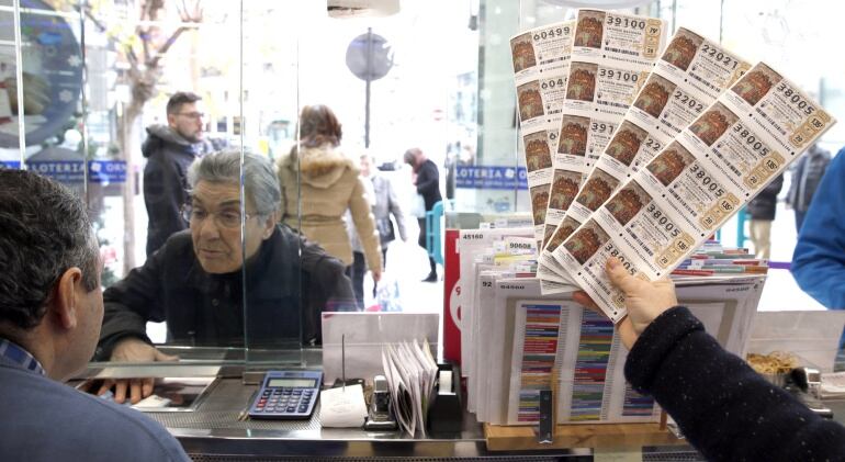 Una persona compra un décimo de Lotería de Navidad en una administración de Bilbao.