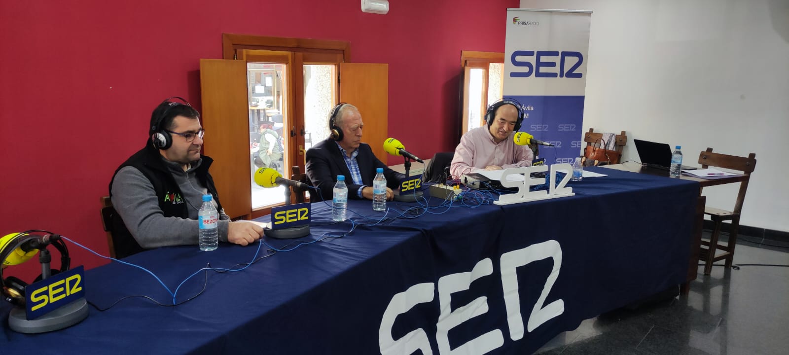 Miguel Ángel Núñez, concejal de fiestas de Navaluenga ySaturnino Herráez, presidente Hermandad de Romanceros hablan con Luis Sánchez en la primera parte del programa