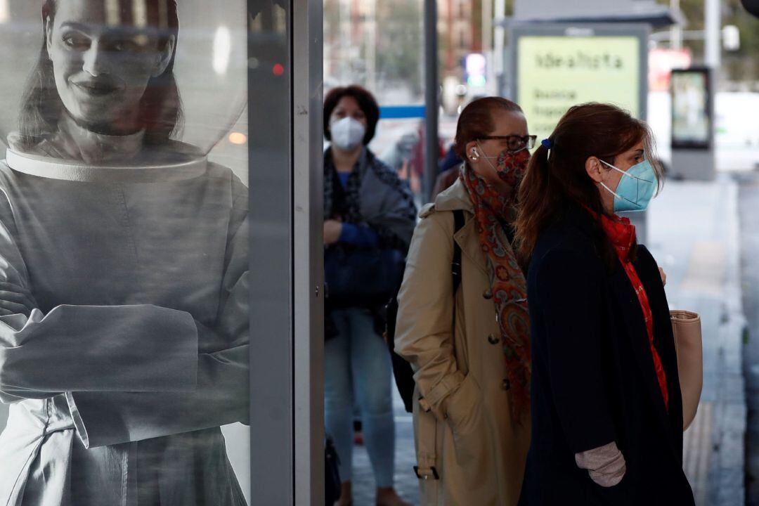 Varias personas se disponen a coger un autobús a las puertas de la madrileña Estación de Atocha 