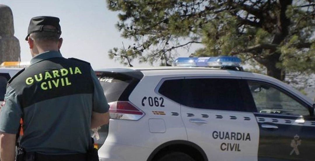 Un guardia civil junto a un coche de la Benemérita.