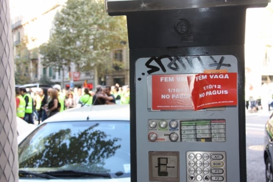 Una màquina de pagament de la zona blava de Barcelona amb enganxines que informen al ciutadà que BSM està en vaga