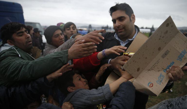 Inmigrantes, que esperaan cruzar la frontera entre Grecia y Macedonia, pelean por comida en un campo provisional cerca de Idomeni