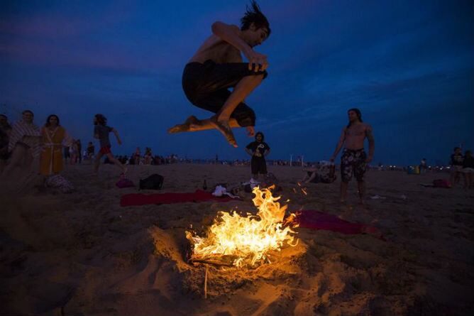 Un joven salta una hoguera durante la noche de San Juan en la playa de la Malvarrosa de Valencia.