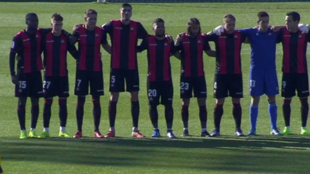 Los jugadores del Reus permanecen inmóviles durante el primer minuto del encuentro ante el Alcorcón