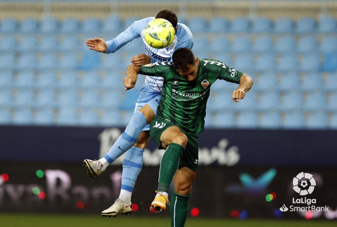 Javi Moyano pelea por un balón ante el Málaga en La Rosaleda