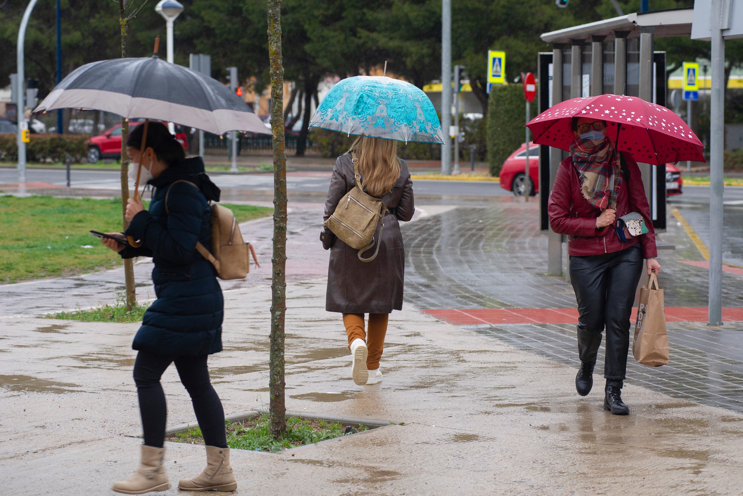 Tres mujeres con paraguas bajo la lluvia