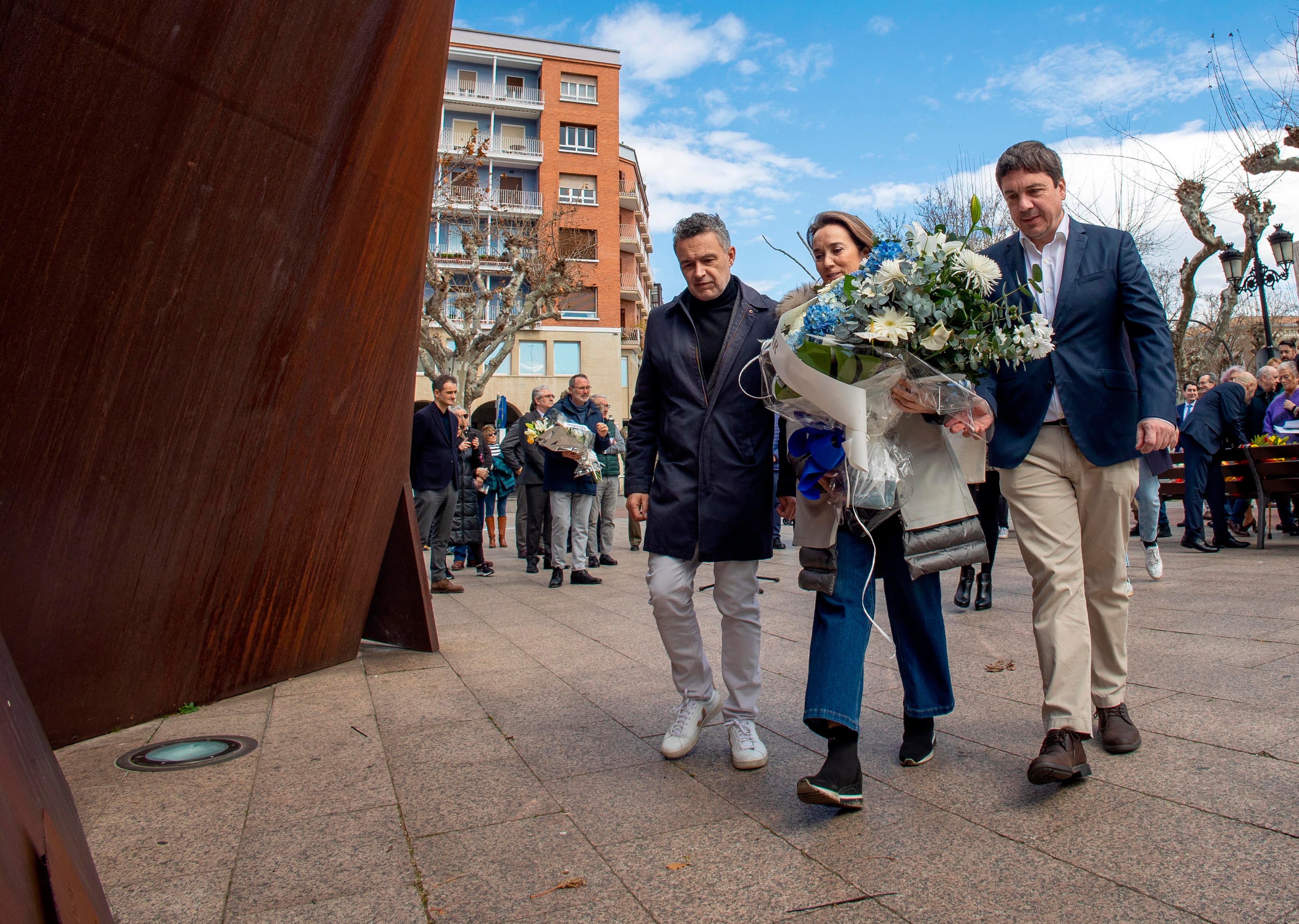 LOGROÑO, 11/03/2023.- La secretaria general del PP, la riojana Cuca Gamarra (c), acompañada por el candidato a la alcaldía de Logroño, Conrado Escobar (i), y por el presidente del partido, Alberto Galiana (d), coloca un ramo de flores este sábado en el acto en conmemoración del Día Europeo de las Víctimas del Terrorismo, celebrado junto al monumento dedicado a las mismas en Logroño y en el que se ha hecho un especial recuerdo a los atentados del 11 de marzo, que tuvieron lugar en Madrid hace 19 años. EFE/Raquel Manzanares