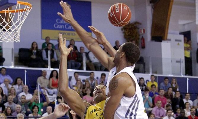 El ala-pívot del Herbalife Gran Canaria Eulis Báez (c) pierde el balón ante el alero estadounidense del Real Madrid Tremmell Darden