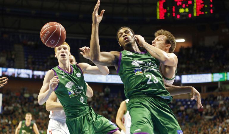 El ala-pívot del Unicaja Jeff Brooks y el base Alberto Díaz luchan por un balón con Rafa Luz.