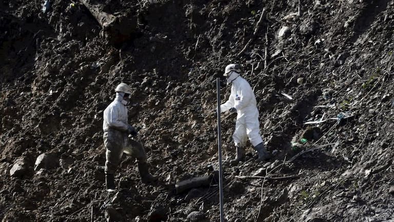 Imagen de archivo de dos operarios trabajando en el vertedero días después del derrumbe en 2020