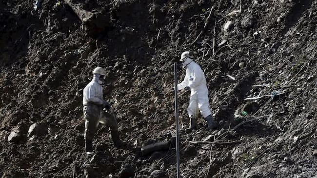 Imagen de archivo de dos operarios trabajando en el vertedero días después del derrumbe en 2020