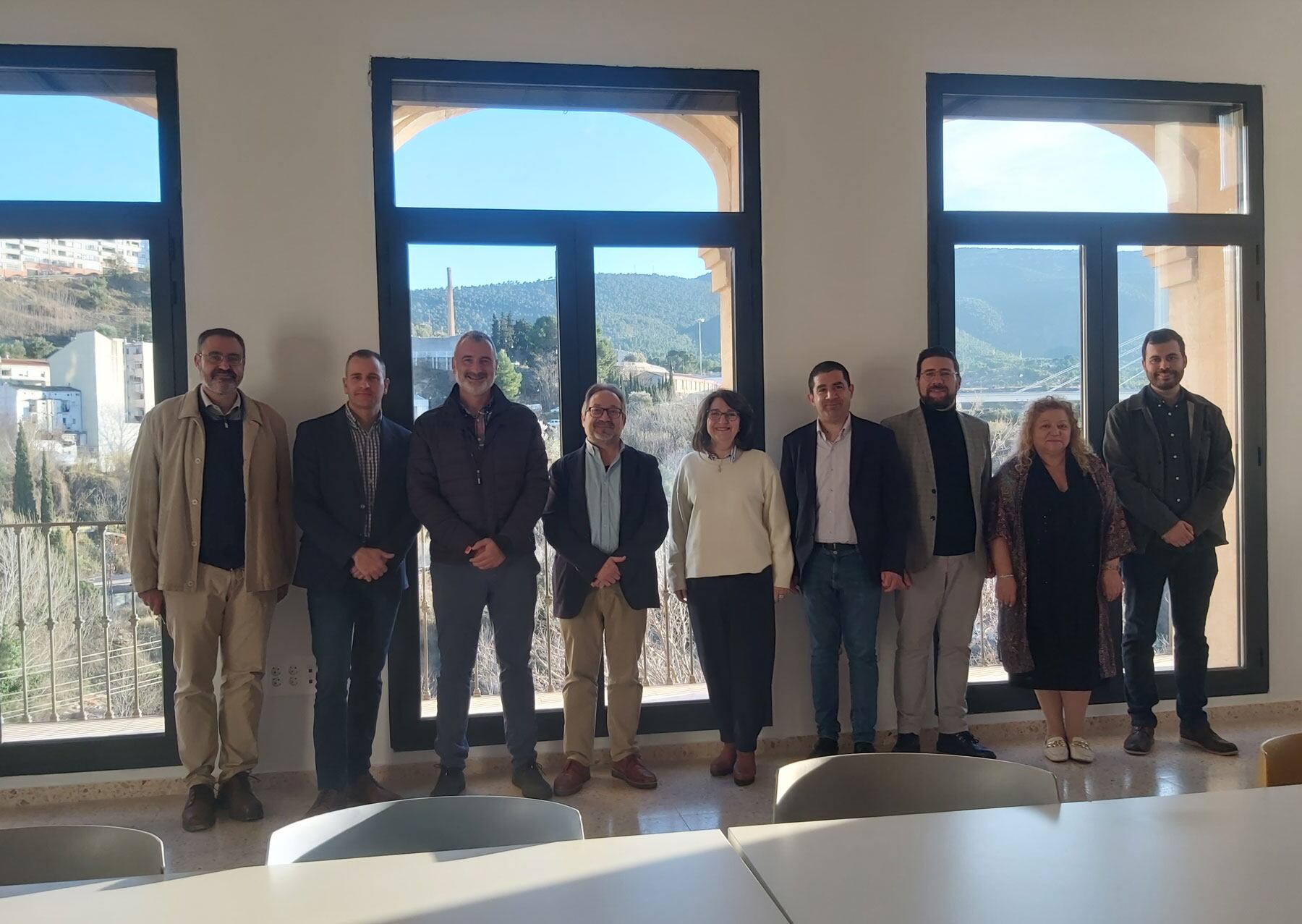 La comitiva posa ante unos grandes ventanales en una de las futuras aulas del Campus de Alcoy de la UA