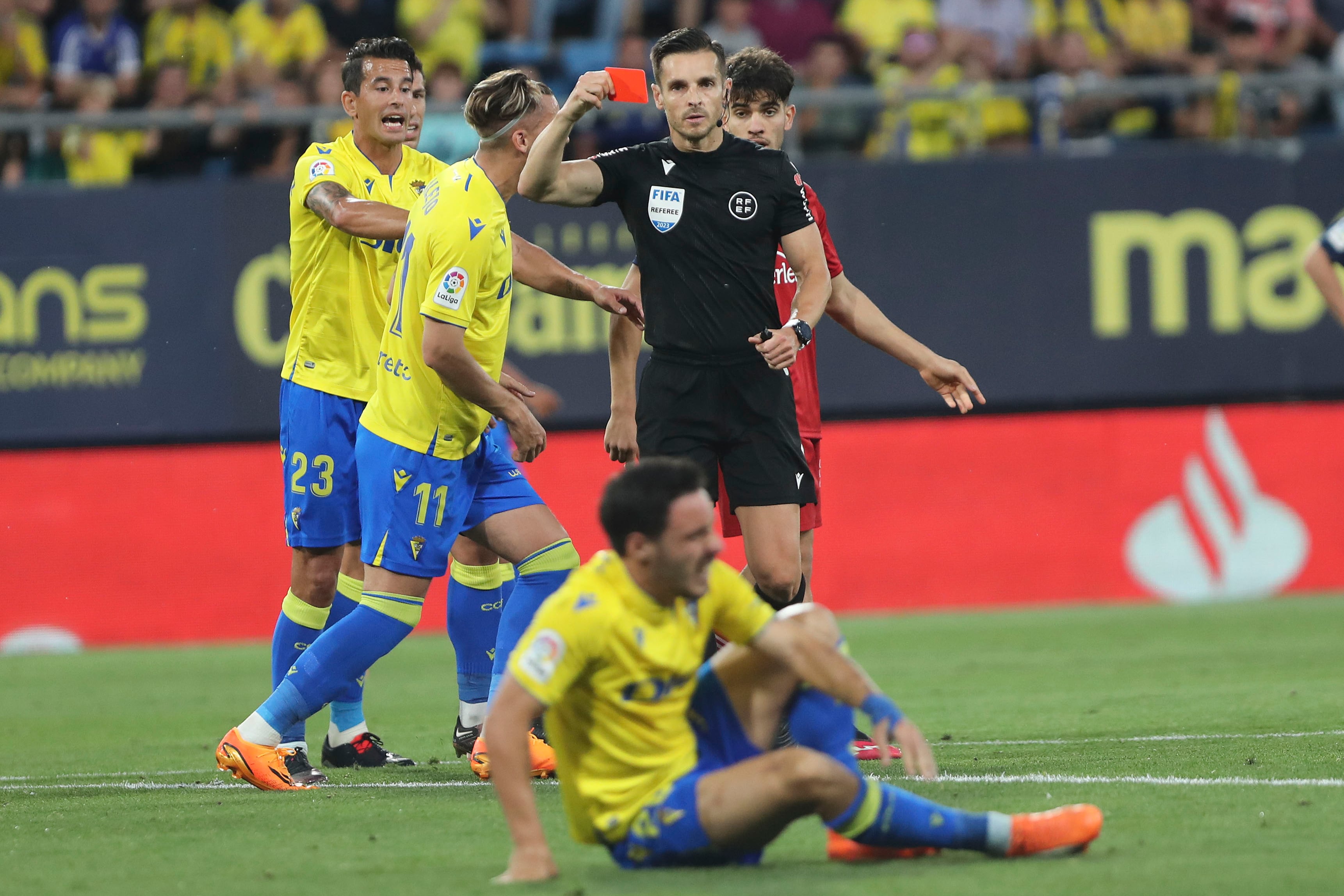 CÁDIZ, 25/04/2023.- El árbitro Del Cerro Grande (2-d) muestra la tarjeta roja a Ez Abde (d), de Osasuna, durante el partido de Liga que enfrenta al Cádiz CF y al Club Atlético Osasuna este martes en el estadio Nuevo Mirandilla. EFE/Román Ríos
