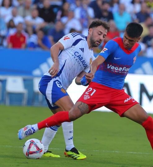 Keidi Bare pugna por un balón con Nico Castro