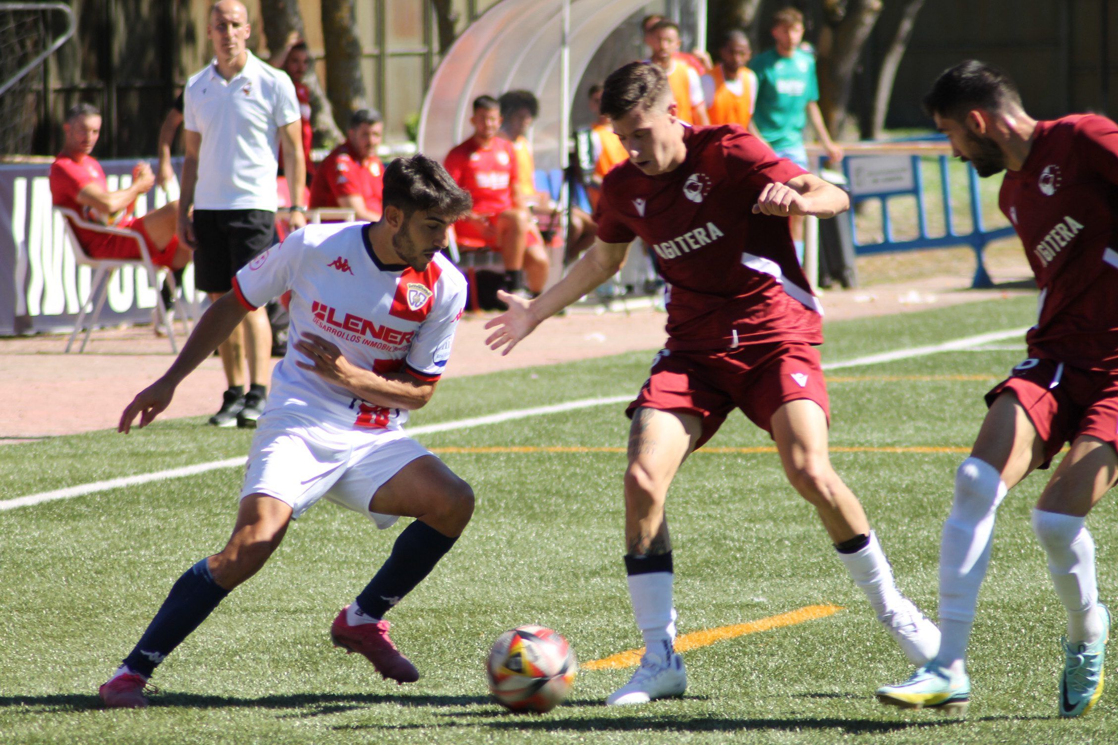 Iván Moreno, en el partido de ida, tratando de zafarse de dos jugadores del Ursaria, Adrián López y el alcarreño Pablo Rojo, bajo la atenta mirada de Joselu y del banquillo deportivista FOTO: CD Guadalajara