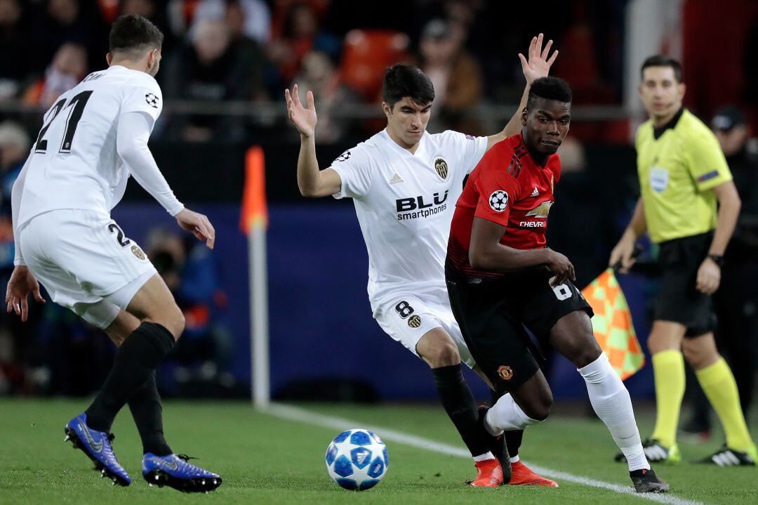 Carlos Soler intenta quitar el balón a Pogba durante un partido de la Champions