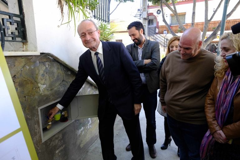 El alcalde de Málaga, Francisco de la Torre, posa en el acto para publicitar la conexión de agua en Colmenarejo ante la mirada del concejal del PSOE, Sergio Brenes, y la viceportavoz de Málaga para la gente, Remedios Ramos