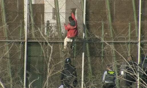 Varios agentes de la Policía golpean a un migrante que ha saltado la valla de Melilla.