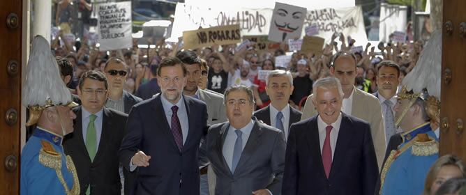 Mariano Rajoy acompañado por el alcalde electo, Juan Ignacio Zoido; el presidente del PP en Andalucía, Javier Arenas, y el secretario general del PP-A, Antonio Sanz, a su llegada al Ayuntamiento de Sevilla donde fueron increpados por numerosos manifestant