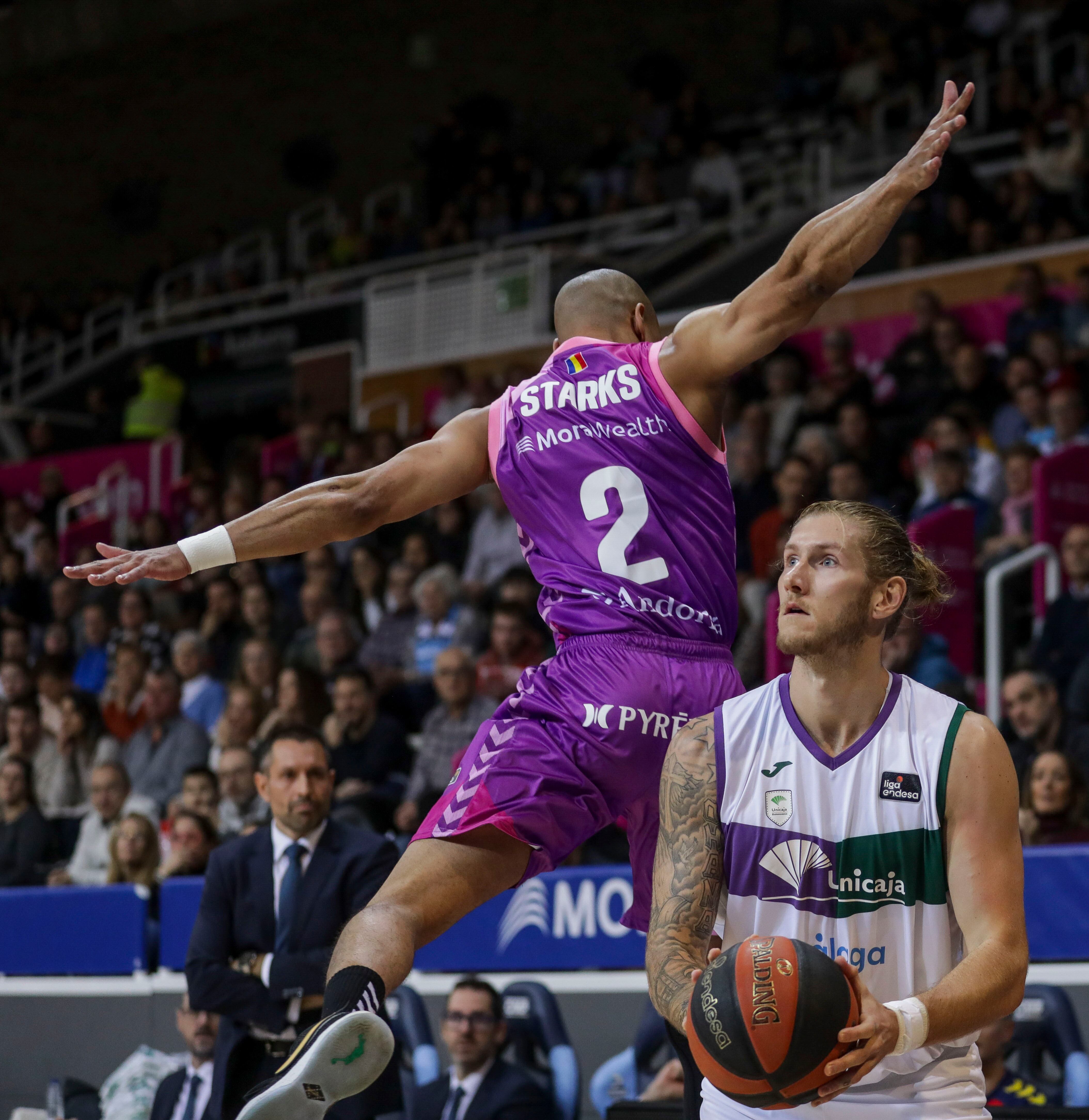 ANDORRA, 09/12/2023.- El ala pivot alemán de Unicaja, Dylan Osetkowski (d), se dispone a lanzar tras realizar una finta al base estadounidense de Morabanc, Markel Starks, durante el encuentro correspondiente a la fase regular de la Liga Endesa que Morabanc y Unicaja disputan hoy sábado en el Polideportivo de Andorra. EFE / Fernando Galindo.