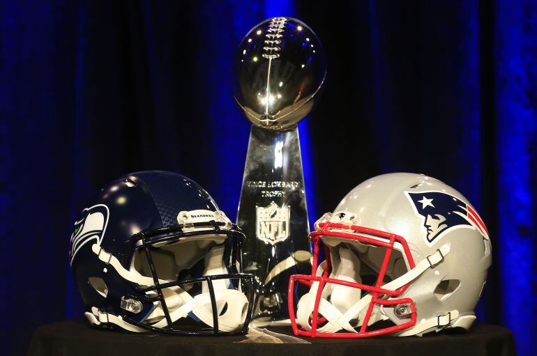 Cascos de los Patriots y los Eagles junto al trofeo. 