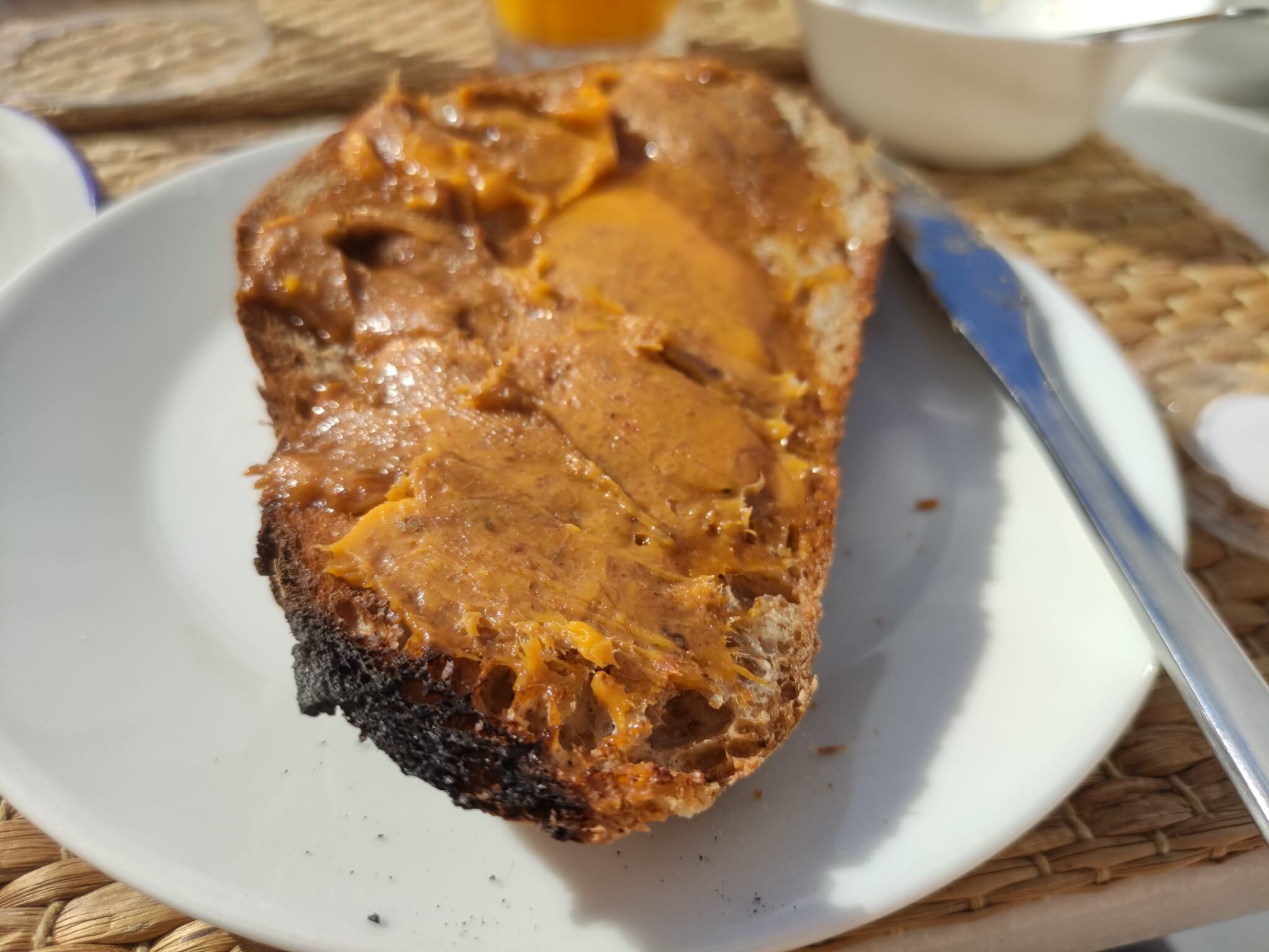 Rebanada de pan de campo con zurrapa de lomo en manteca colorá, en la terraza de La Fonda Antigua