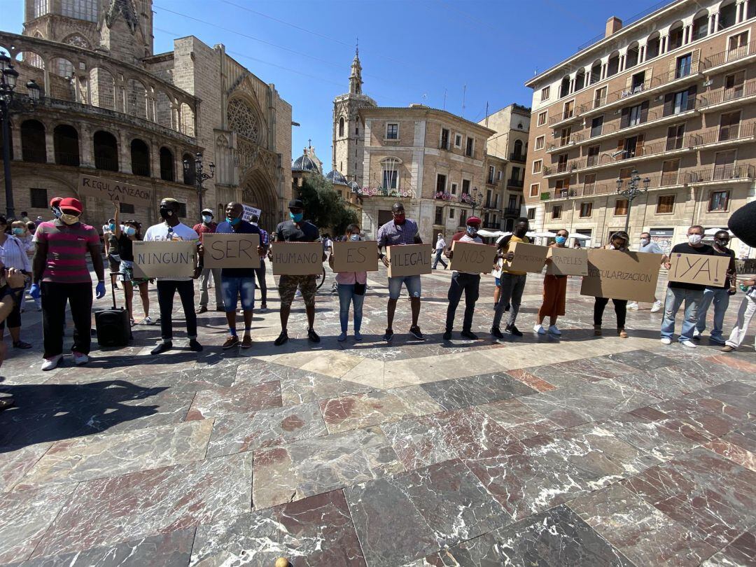 Plataformas pro derechos humanos se manifiestan en la plaza de la Virgen de València para pedir la regularización de los migrantes.