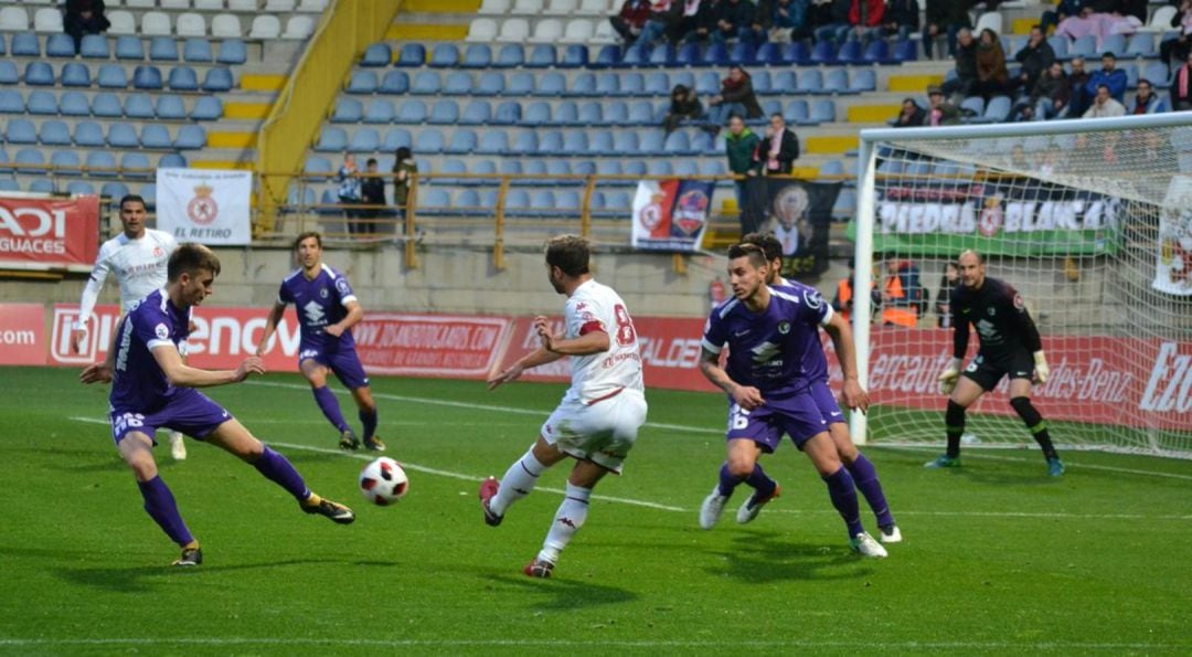 Antonio Martínez centra rodeado por tres rivales