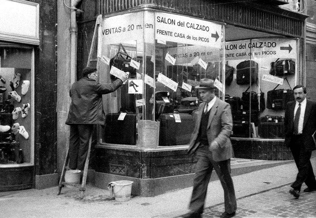 El limpiacristales en acción en el escaparate de El salón del calzado