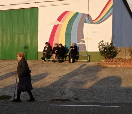 Vecinos de Pescueza descansan en un banco durante la puesta de sol