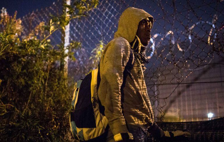 Un hombre aguarda cerca del Eurotunel, pendiente de la seguridad de las vallas.