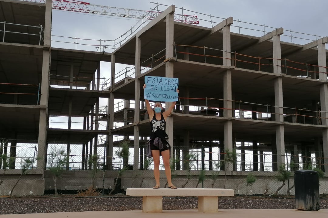 Una manifestante frente al esqueleto del hotel de la Playa de La Tejita (Granadilla, Tenerife) en donde un grupo de personas se encaramaron sobre una grúa con la intención de paralizar la obra