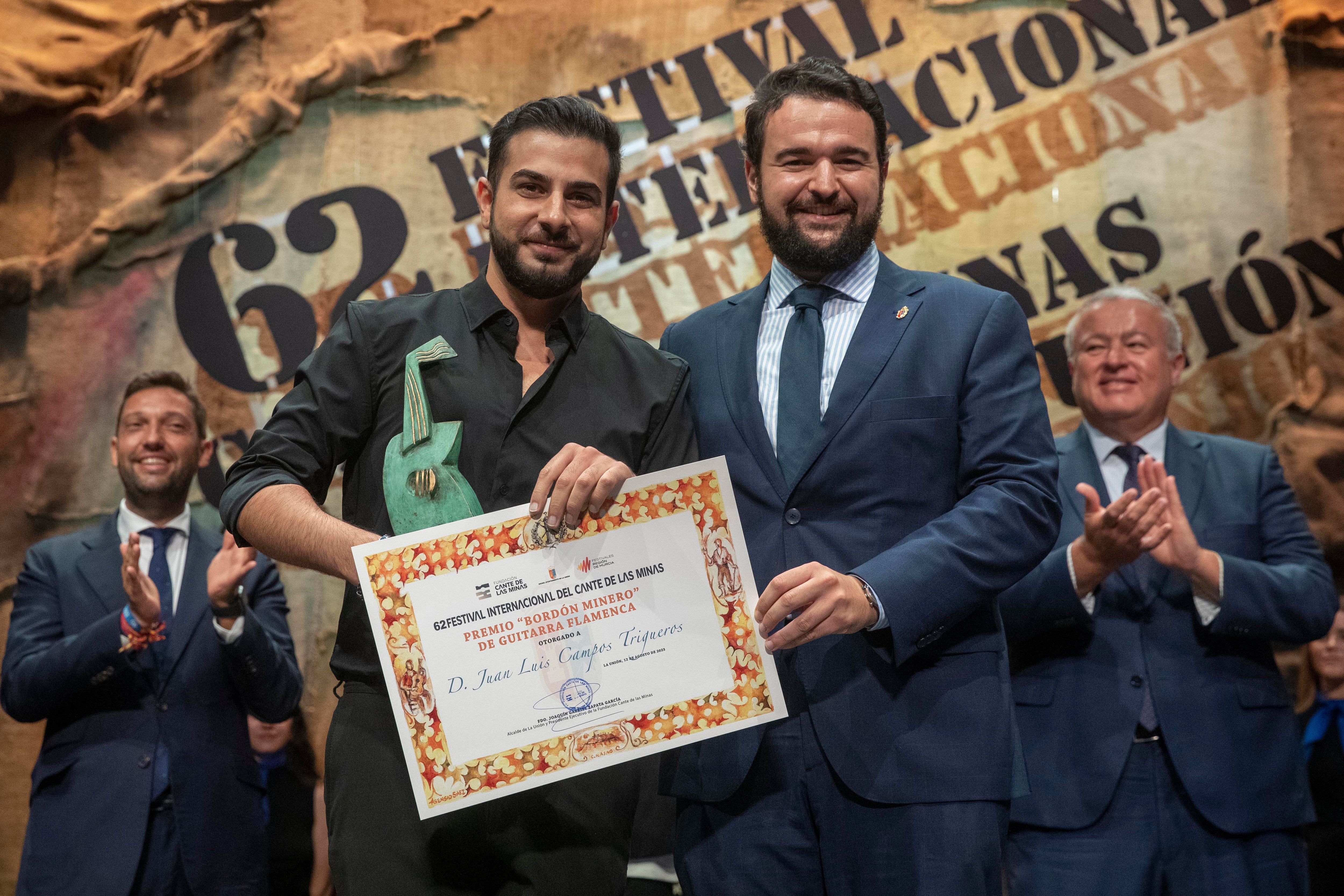 El guitarrista granadino Juan Luis Campos Triguero &quot;El Poti&quot; (i) recibe el &quot;Bordón Minero&quot; de manos del alcalde de la Unión, Joaquín Zapata (d), anoche tras la final del Festival Internacional del Cante de las Minas de La Unión en el antiguo mercado público Catedral del Cante en la Unión (Murcia)