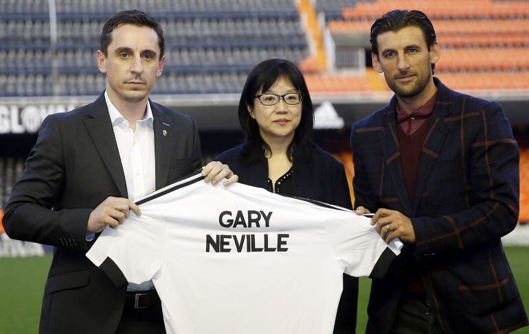 El técnico inglés Gary Neville (i), posa con la presidenta del Valencia, Lay Hoon Chan, y el exjugador, Angulo (d), durante su presentación esta tarde en el estadio de Mestalla como entrenador de la primera plantilla del Valencia C.F. hasta el próximo 30 de junio. EFE-Kai Försterling