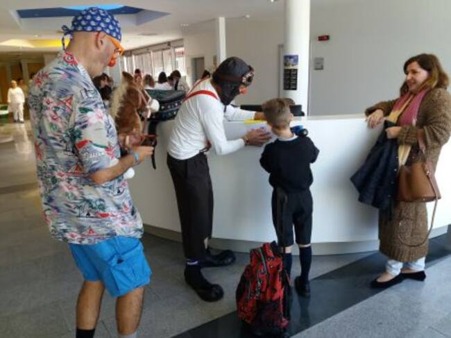Un niño "firma" su ficha de ingreso en el Hospital de la mano de los payasos de "Tropezones" y en presencia de su madre