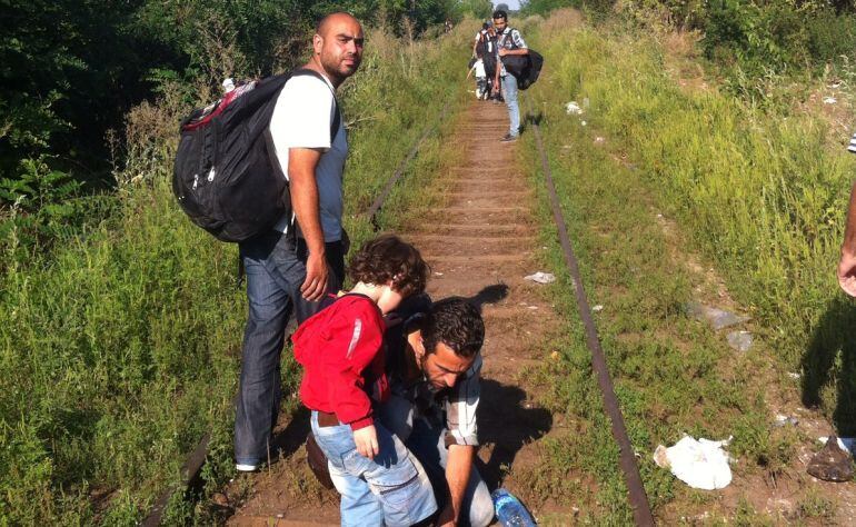 Los inmigrantes caminan por las vías de tren que van de Serbia a Hungría.