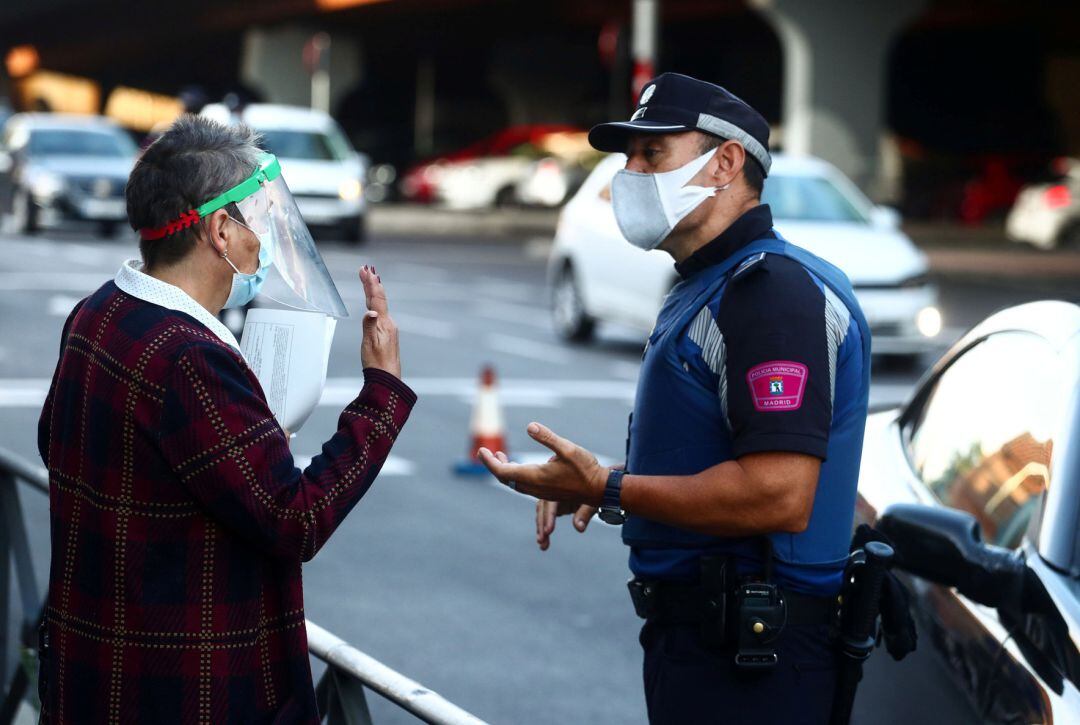 Un miembro de la policía local conversa con una mujer.