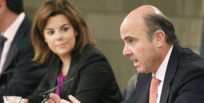 El ministro de Economía, Luis de Guindos, junto a la vicepresidenta del Gobierno, Soraya Sáenz de Santamaría, durante la rueda de prensa posterior al Consejo de Ministros de este viernes