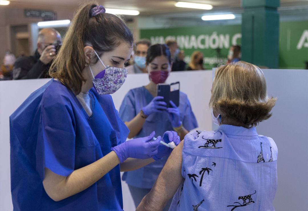 Una sanitaria vacuna a una mujer en la primera jornada de vacunación