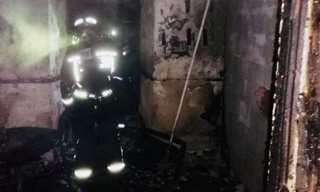 Un bombero durante la intervención en la casa incendiada de Los Villares.