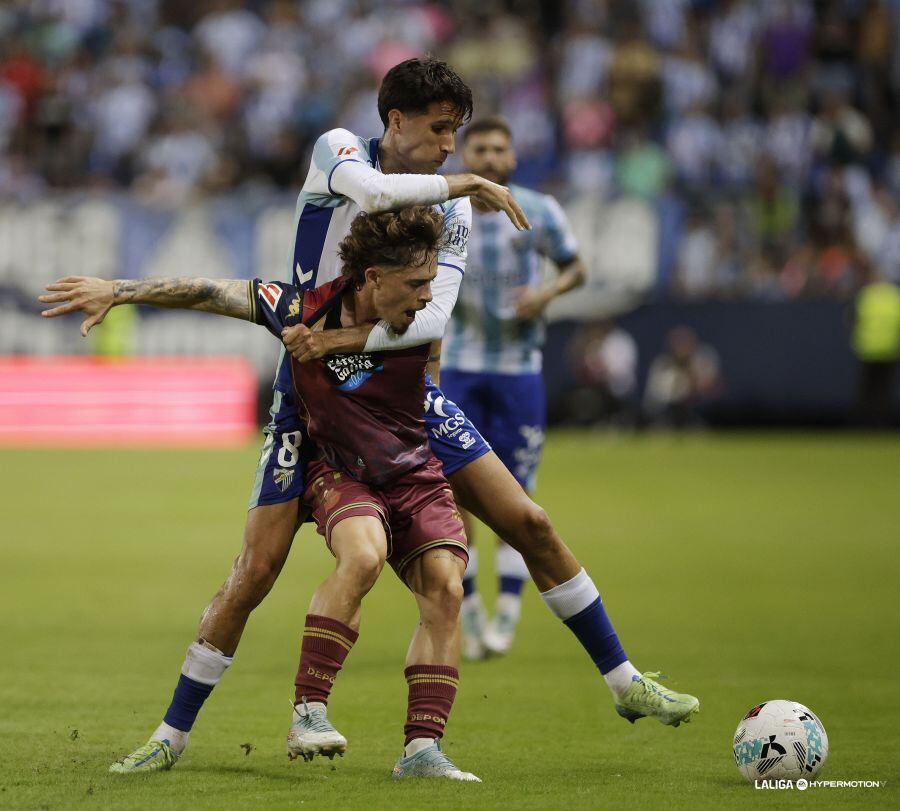Juanpe disputa el balón con el deportivista Mario el pasado domingo en La Rosaleda