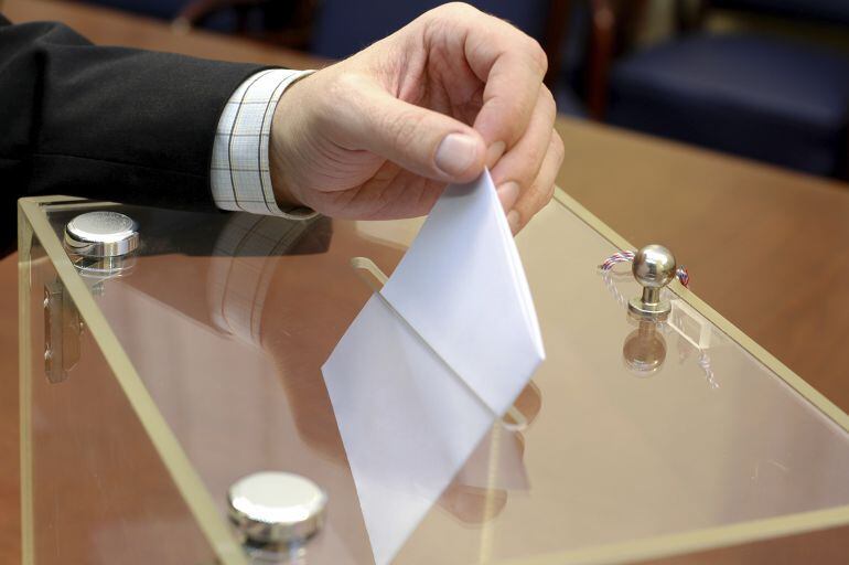 Un hombre deposita su voto.