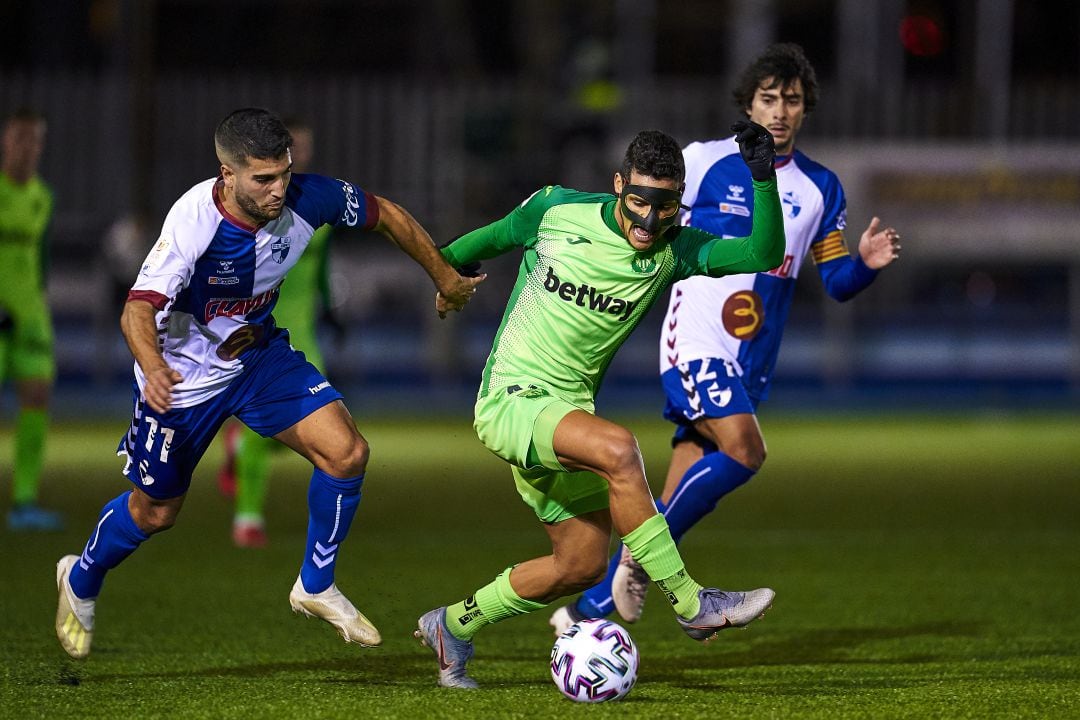 El pepinero Rosales (que lució una aparatosa máscara) conduce el balón perseguido por Juampa (CD Ebro) en el partido de este jueves en Zaragoza.