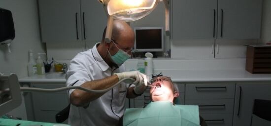 Un dentista atiende a un paciente en su consulta