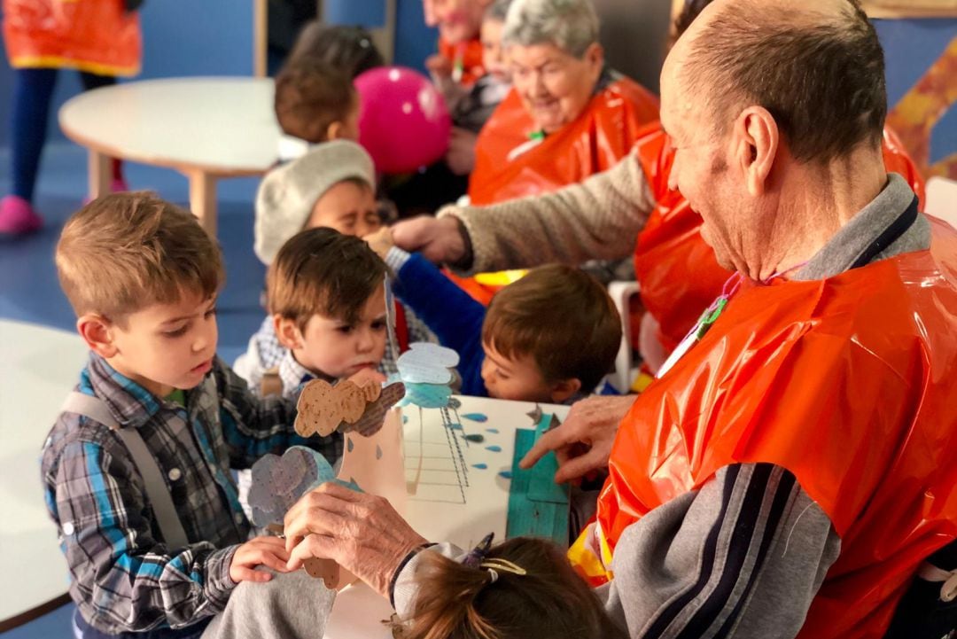 Varios niños, disfrazados de abuelos por carnaval, se acercan a escuchar la lectura del cuento.