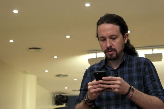 El secretario general de Podemos, Pablo Iglesias, mira su móvil poco antes de comparecer ante los medios de comunicación